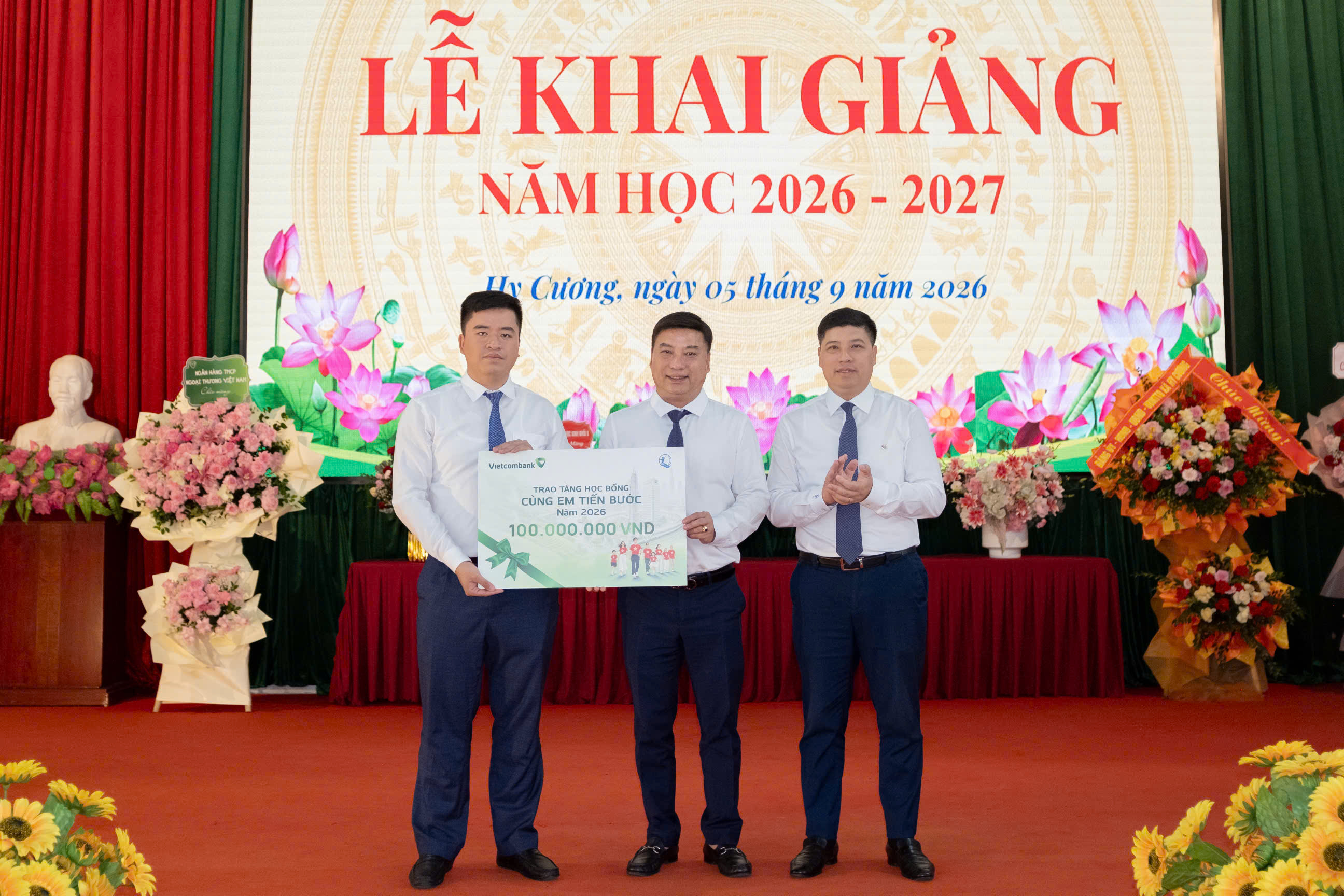 Đồng chí Đinh Tiến Hải cùng đại diện Vietcombank trao biển tượng trưng 100 suất học bổng cho xã Hy Cương